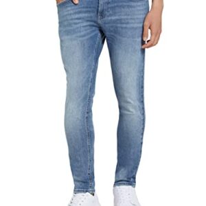 Mann in passender Skinny Culver Jeans aus Bio-Baumwolle, die eine moderne und stylische Silhouette betont, mit klassischem Five-Pocket-Stil und lässigen Sneakers.