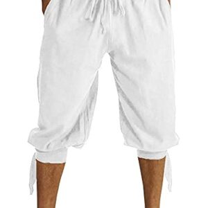 Mann in weißen Shorts und Hosen, steht mit den Händen auf dem Po. Der Hintergrund ist ein starkes Weiß, das sich vom Kleidungsstil abhebt. Es gibt keinen Text oder andere Objekte im Bild. Die Aufmerksamkeit gilt ausschließlich dem Mann und seiner Bekleidung.